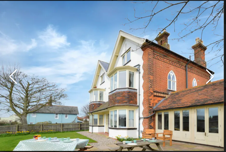 Elegant brick and white countryside house with garden.